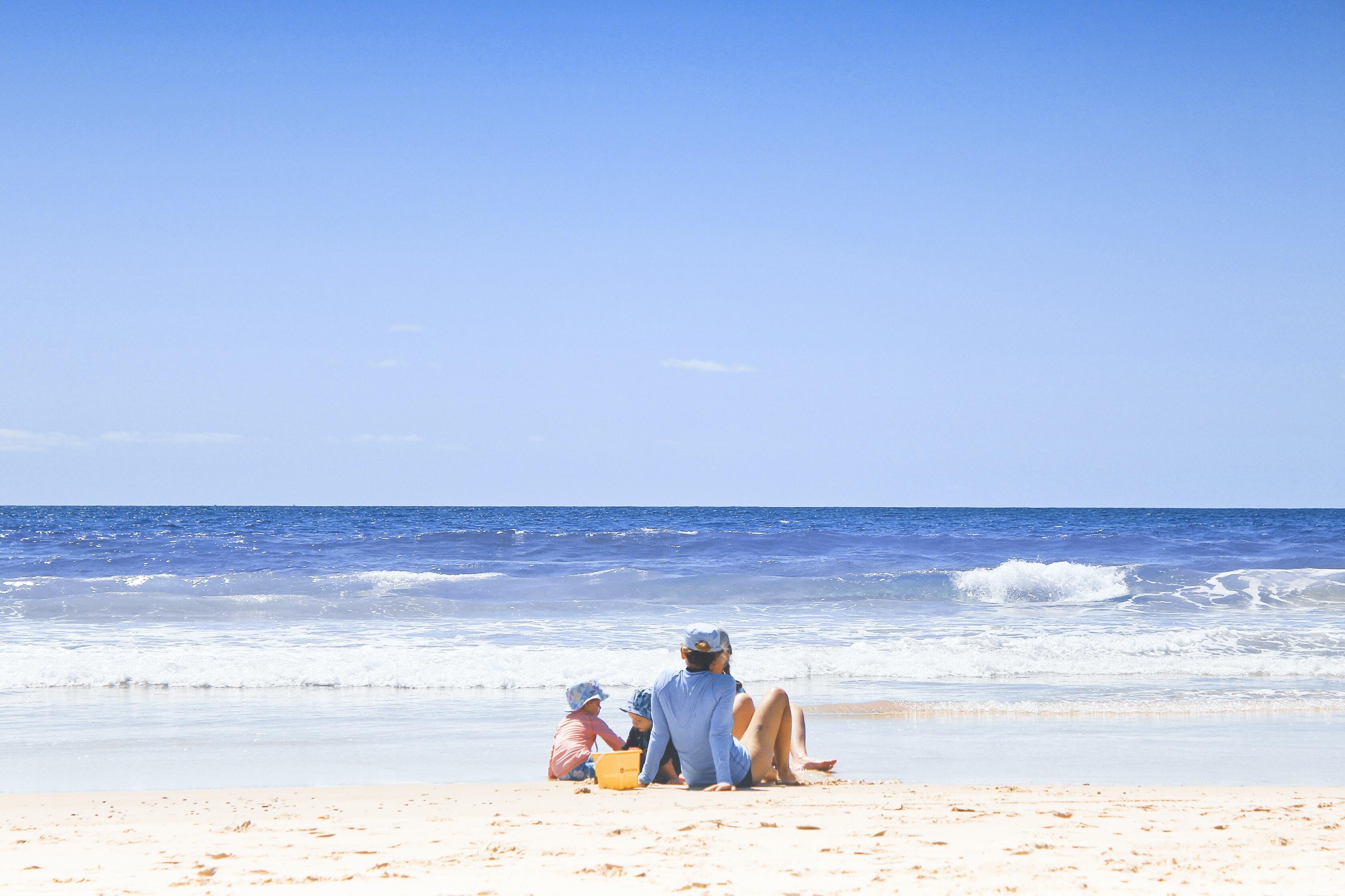Family sitting on beach watching waves